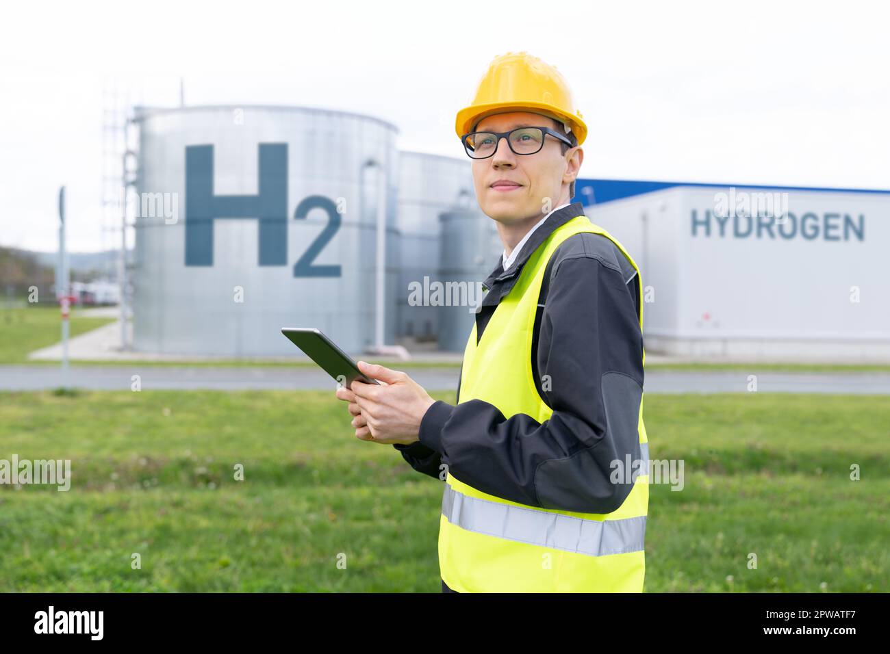 Engineer with tablet computer on a background of Hydrogen factory. High quality photo Stock Photo