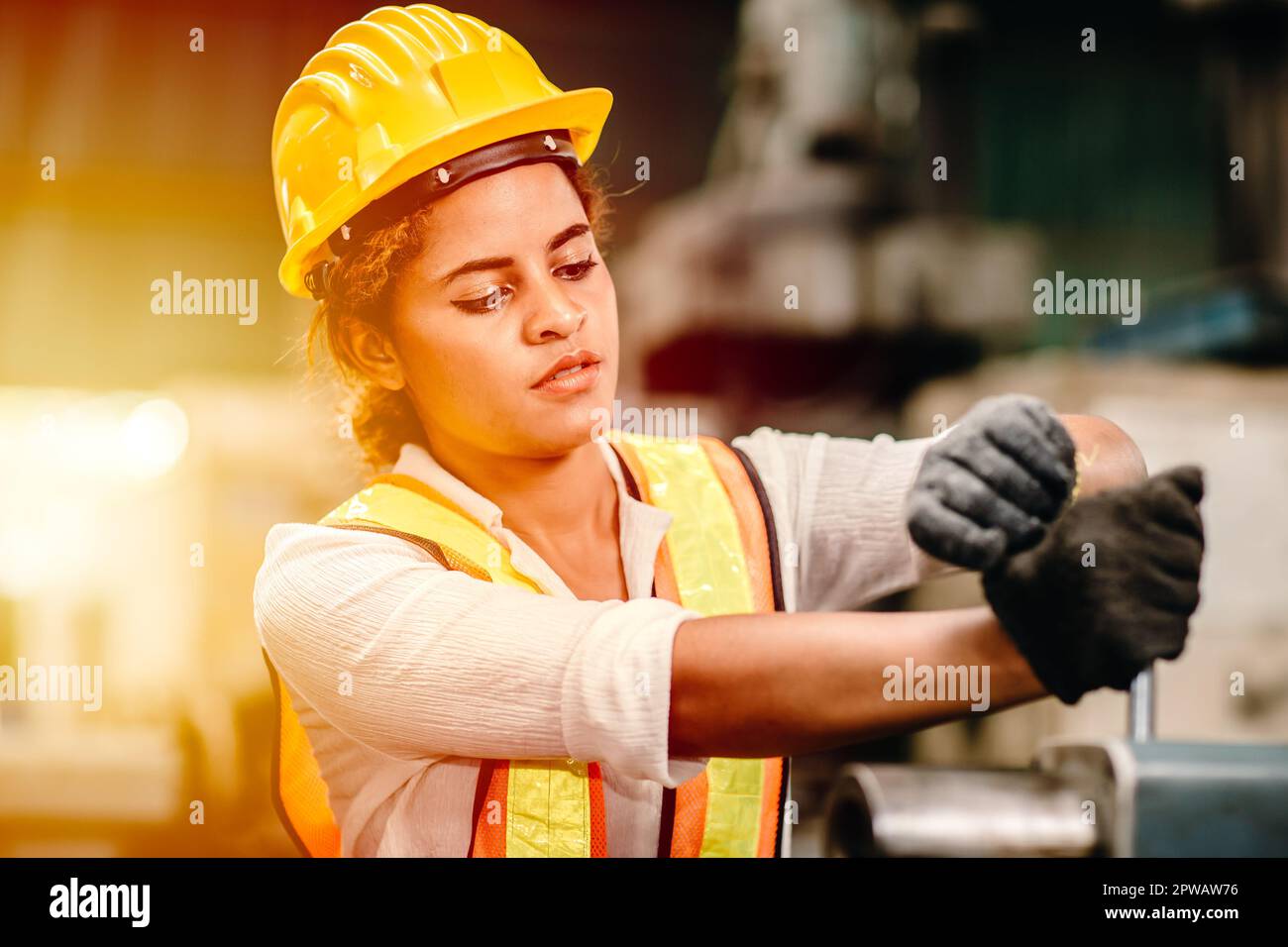 African American woman worker with safety suit helmet  working in heavy metal industry factory hardworking women. Stock Photo