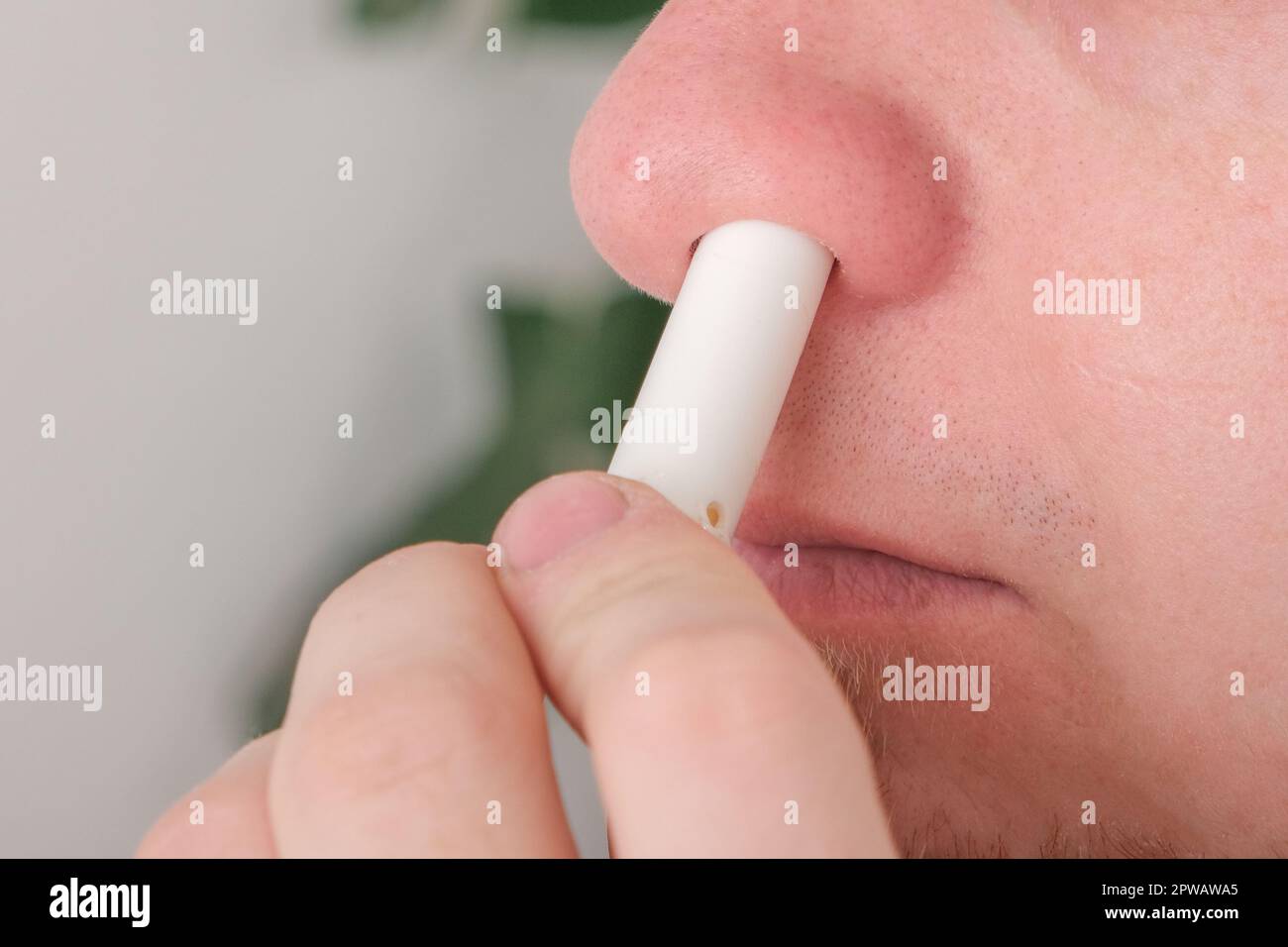 Adult man uses nasal stick inhaler to smell for relieve dizzy and faint