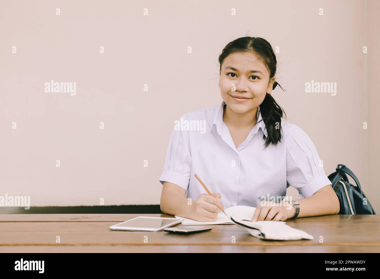 portrait southeast asian young teen student sitting education learning in school uniform with copy space. Stock Photo