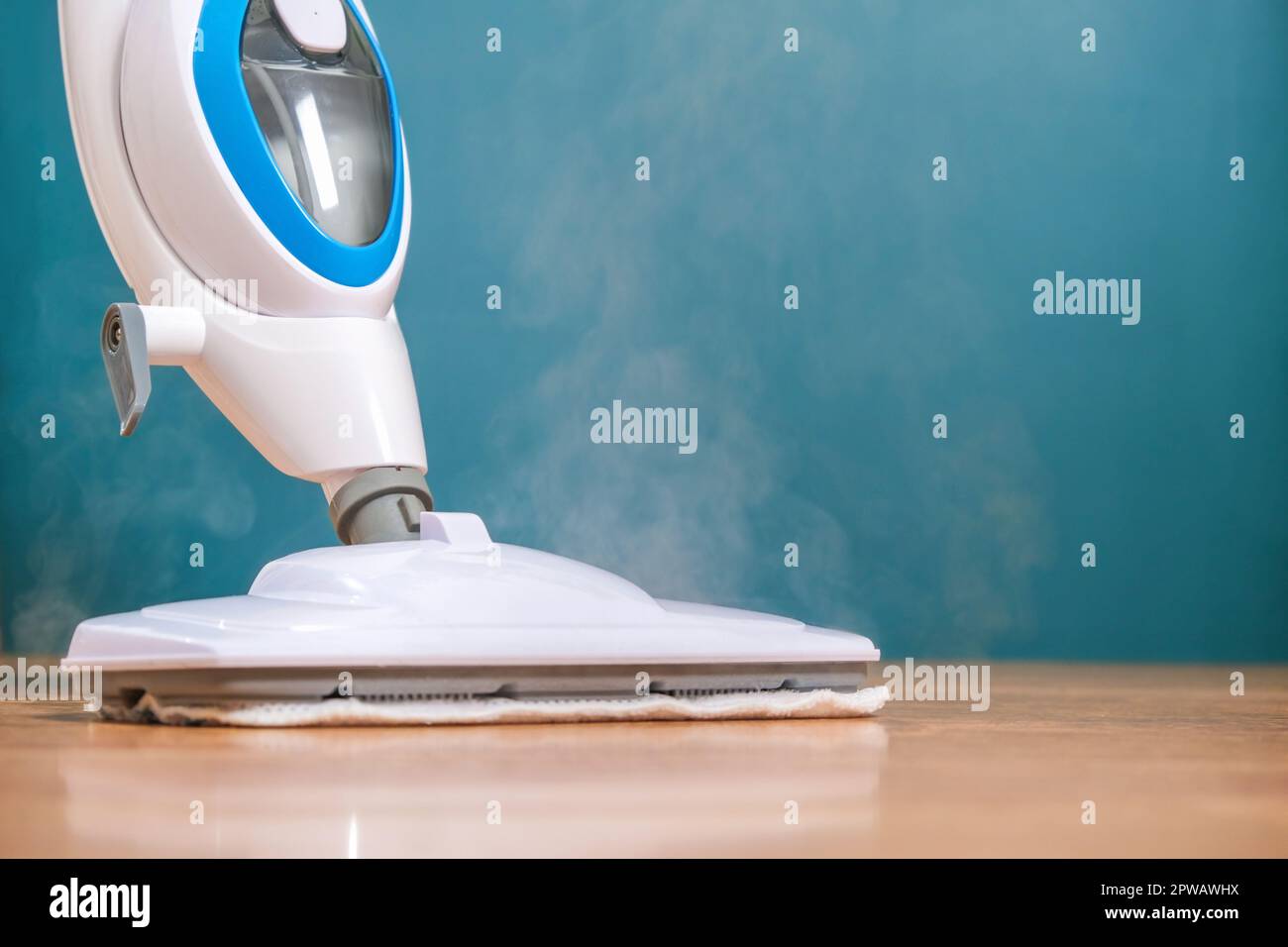 A man washes the floors with a steam mop. Floor treatment with hot ...