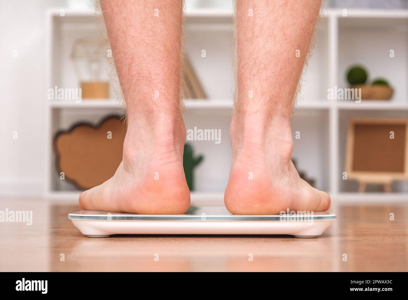 https://c8.alamy.com/comp/2PWAX3C/a-man-stands-on-the-scales-the-guy-is-weighing-himself-floor-scales-for-health-weight-control-2PWAX3C.jpg