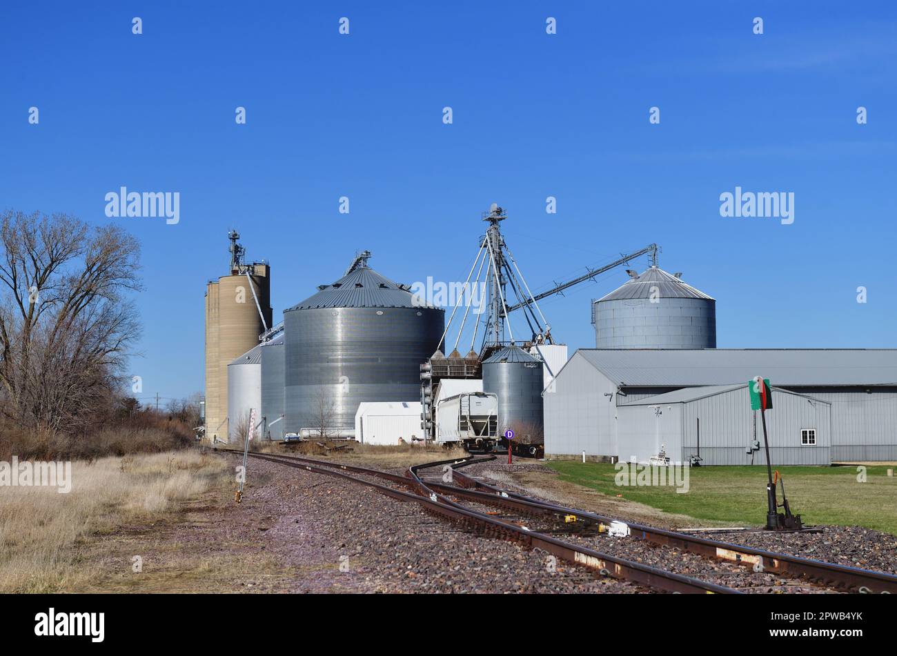 Earlville, Illinois, USA. Grain elevators at a farmers cooperative complex beside a railroad branch line in a small north central Illinois community. Stock Photo