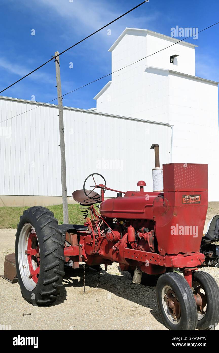 Waterman, Illinois, USA. A vintage tractor provides a foreground to a community farmers cooperative in a small north central Illinois town. Stock Photo