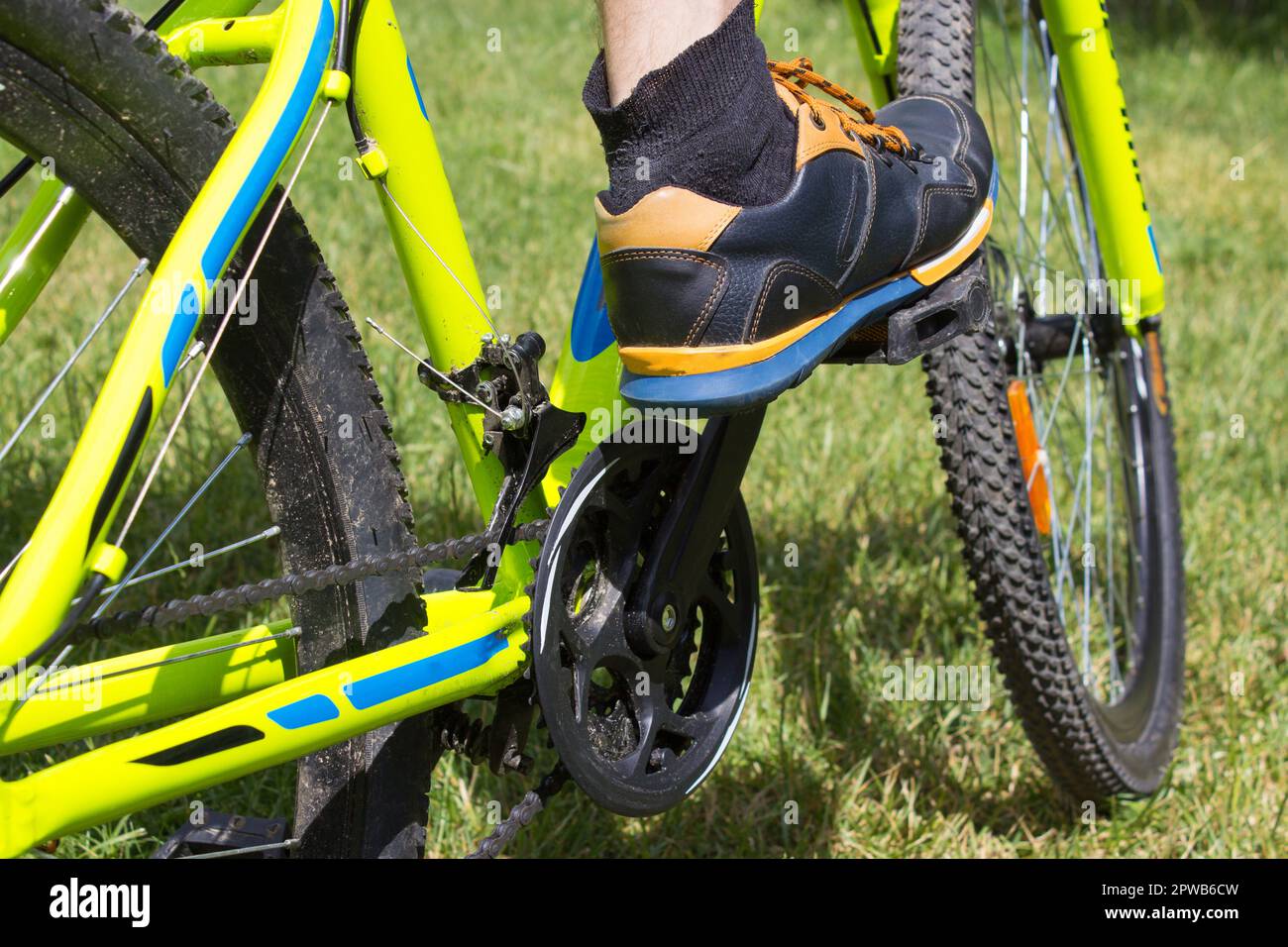 Close up of the leg stand on the bike pedal on the grass Stock Photo