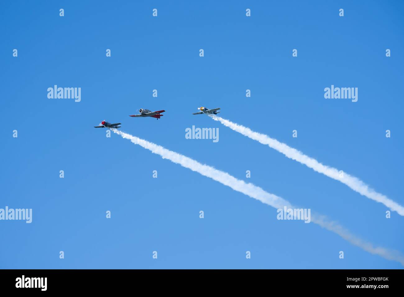 Tauranga New Zealand - April 25 2023; Three Harvard vintage planes in wide blue sky overhead fly-past. Stock Photo