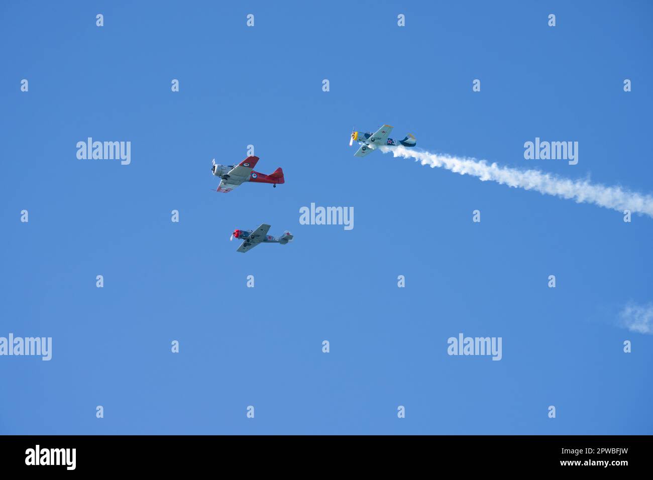 Tauranga New Zealand - April 25 2023; Three Harvard vintage planes in wide blue sky overhead fly-past. Stock Photo