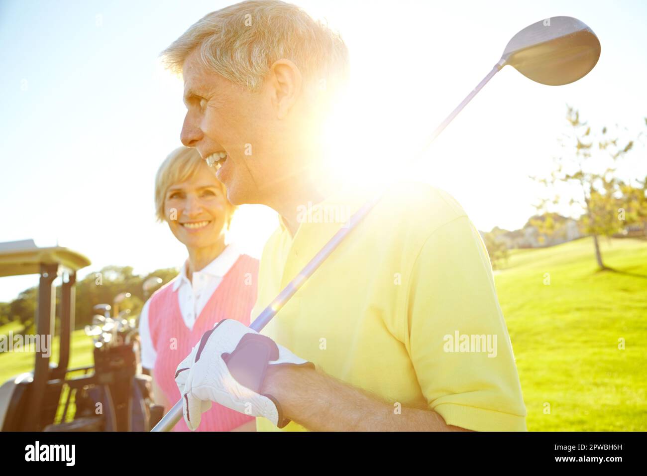 Living out their retirement dreams. Attractive elderly couple with their golf clubs over their shoulders. Stock Photo