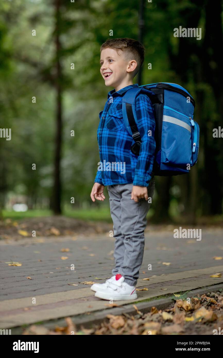 Portrait of a first grader with a backpack. The boy goes to school