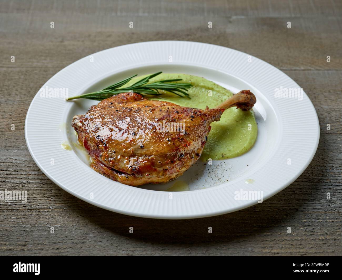 duck leg confit and broccoli puree on white plate Stock Photo
