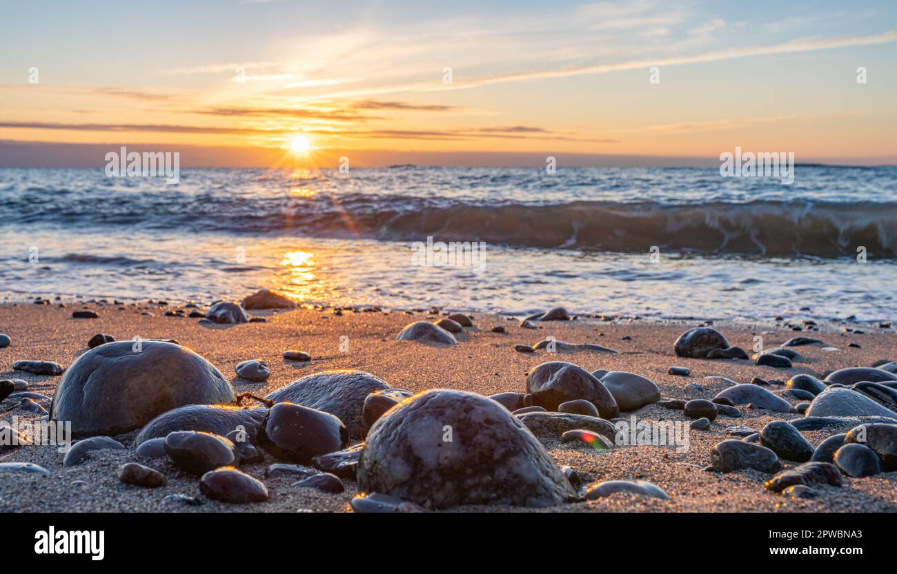 dreamlike, orange, sunset between rocks in the sea of the Baltic Sea ...