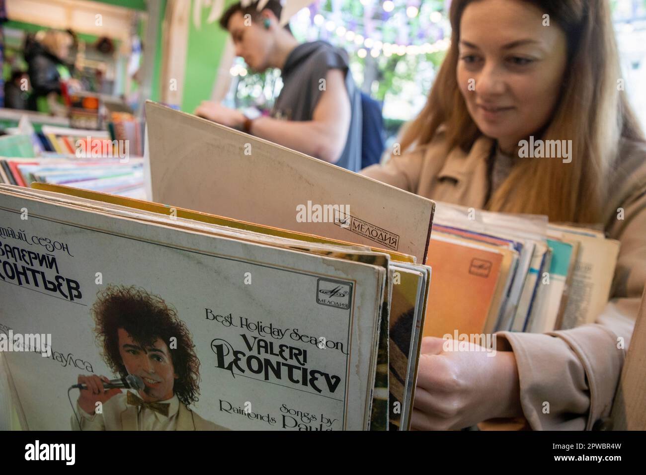 Moscow, Russia. 29th of April, 2023. A woman chooses records of Soviet artists at a flea market of old things on Gogolevsky Boulevard, as part of the Moscow Spring Festival, Russia Stock Photo