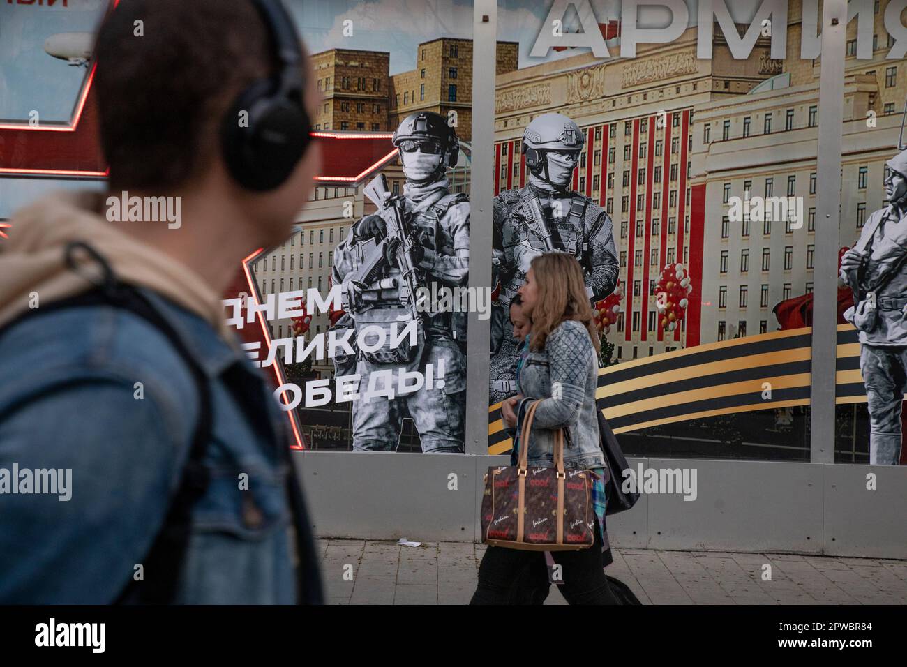 Moscow, Russia. 29th of April, 2023 People walk past the Army of Russia store with a festive banner for Victory Day celebration in the shop window in central Moscow, Russia. The banner reads 'Army of Russia!' Stock Photo