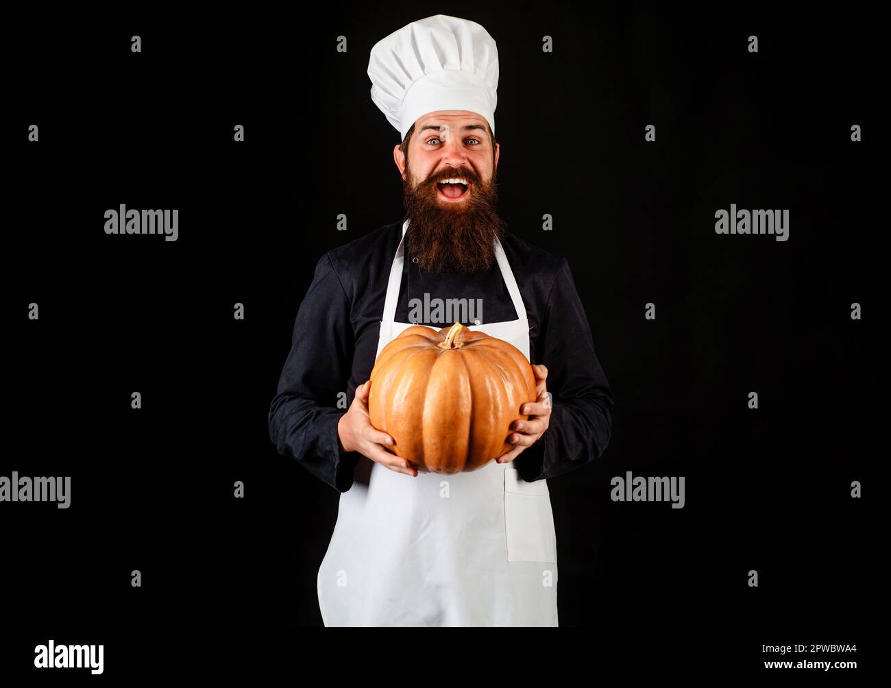 Autumn vegetables. Male cook in chef hat with pumpkin. Healthy vegetarian eating. Chef in uniform and white apron with squash. Diet food. Farm market Stock Photo