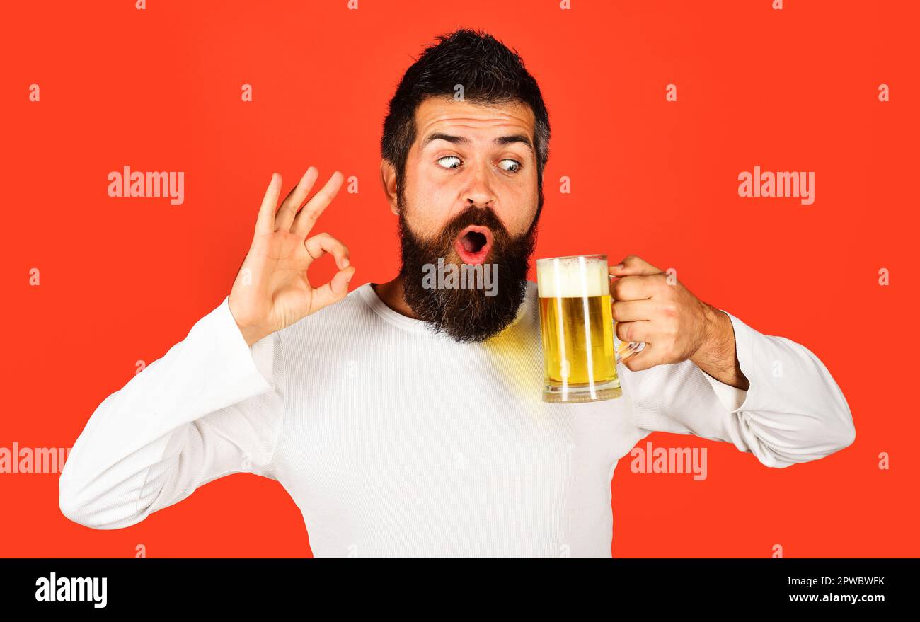 Beer time. Bearded man with beer mug showing sign ok. Man with craft