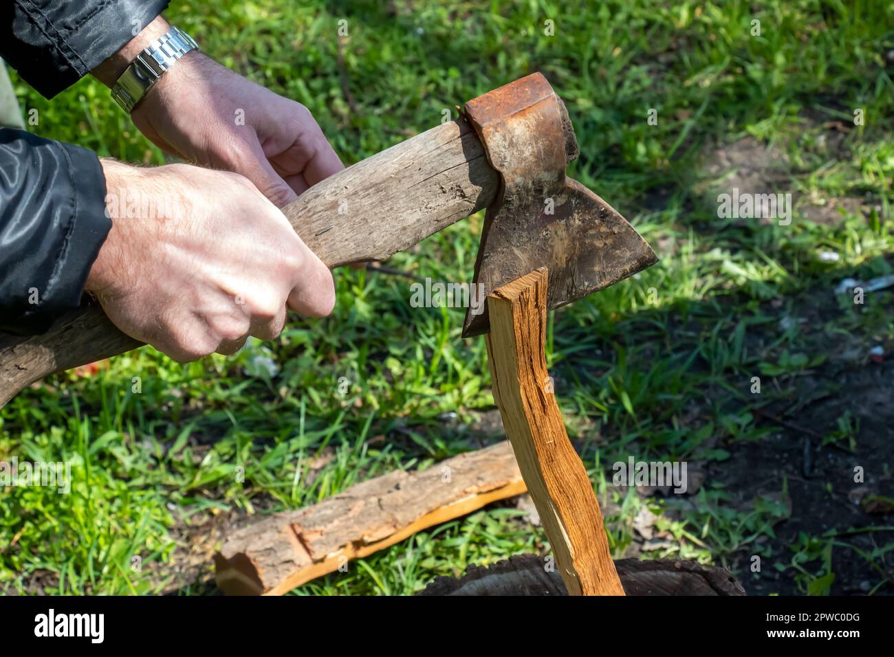 A man is chopping wood for a home fireplace. Vacation concept in the countryside Stock Photo