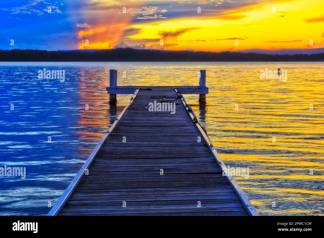 Timber boat fishing jetty on Lake Macquarie at Cams Wharf Murrays beach in  Australia at sunset Stock Photo - Alamy