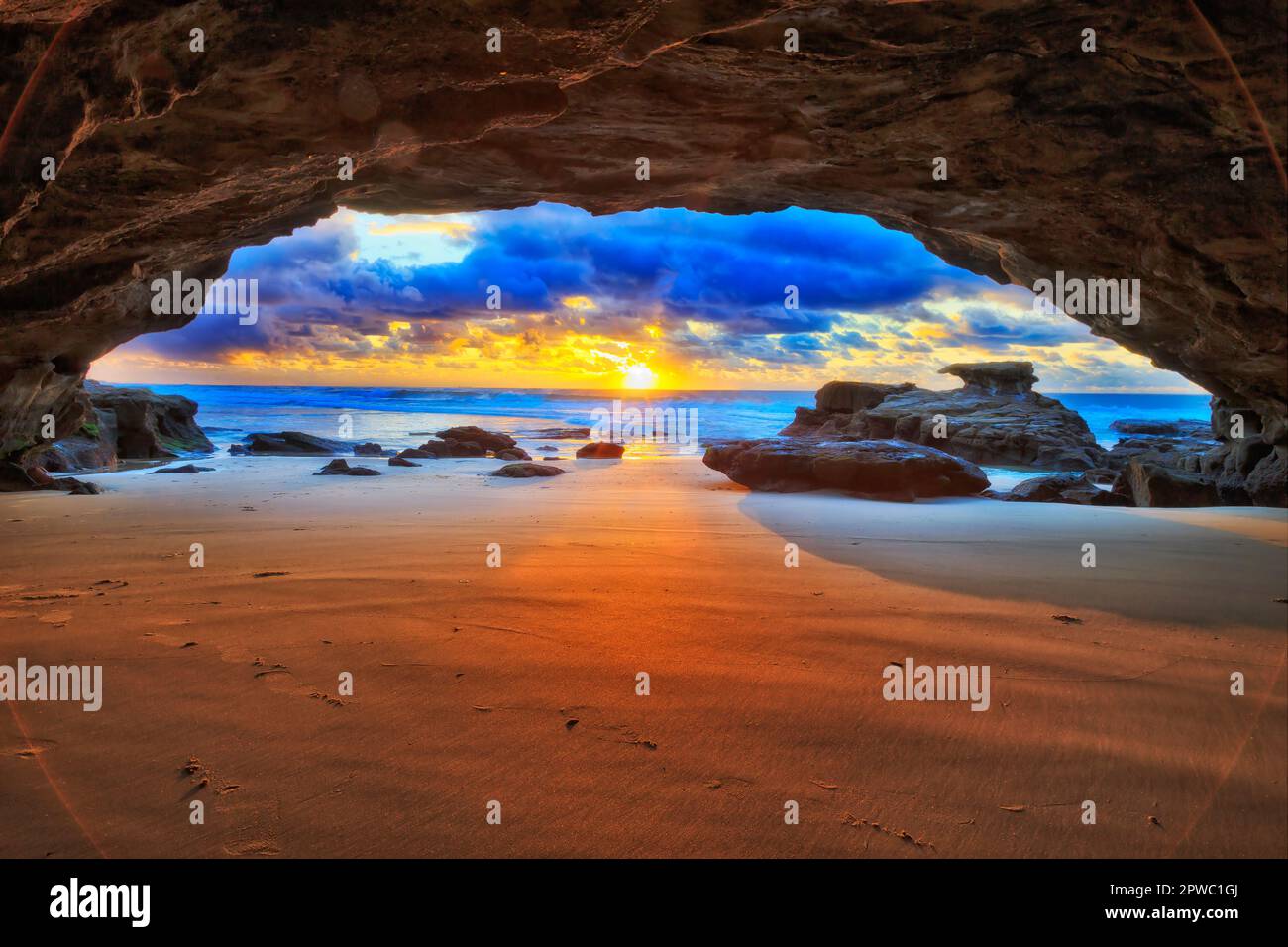 Scenic colourful sunrise from inside sea cave on Caves beach Pacific