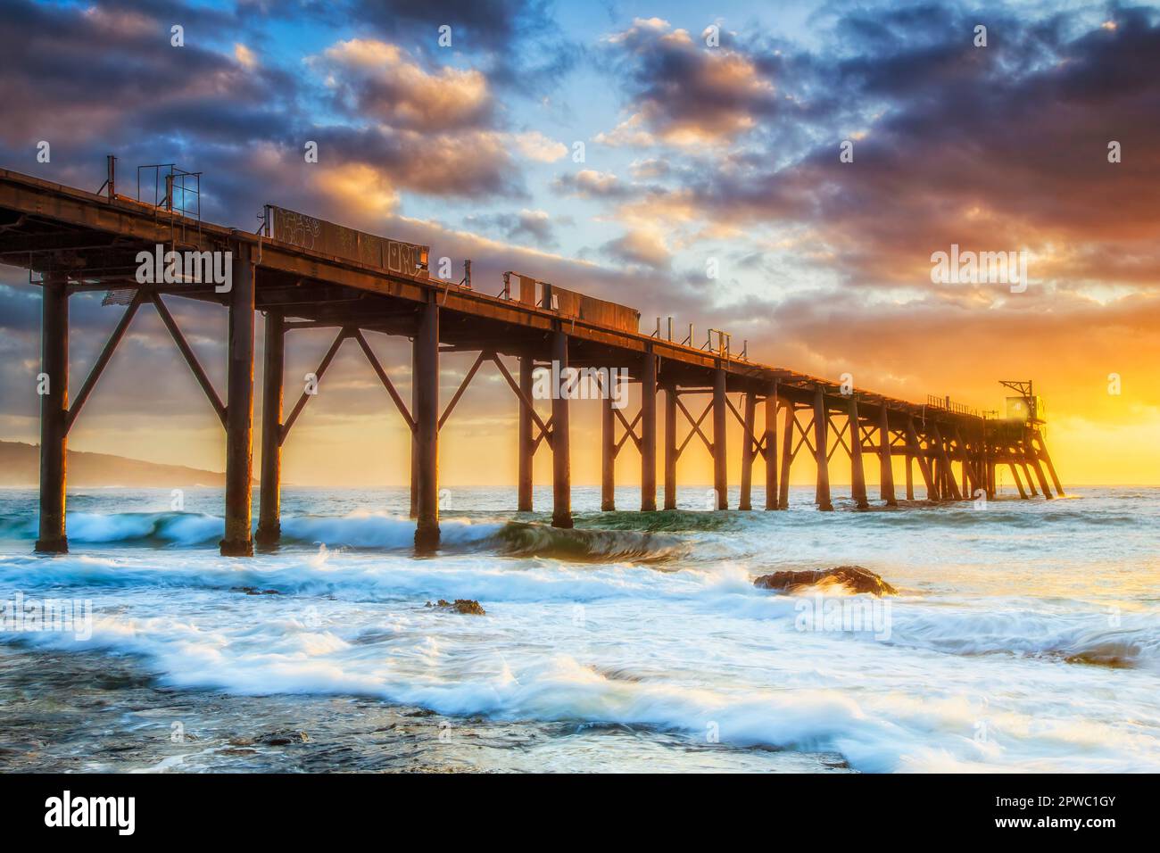 Soft warm light on old historic timber jetty off Catherine Hill bay Middle camp beach of Australian Pacific coast. Stock Photo