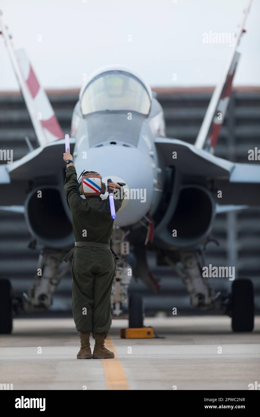 U.S. Marine Corps Cpl. David Nelson, a fixed-wing aircraft mechanic with Marine Fighter Attack Squadron 115, Marine Aircraft Group 12, signals to a pilot before a flight at Gwangju Air Base, Republic of Korea, during the Fiscal Year 2023 Korea Flying Training, April 19, 2023. KFT 23 is a combined training event focused on tactical execution of combat missions and is part of the ROK-U.S. alliance's routine, annual training program. (U.S. Marine Corps photo by Cpl. Tyler Harmon) Stock Photo