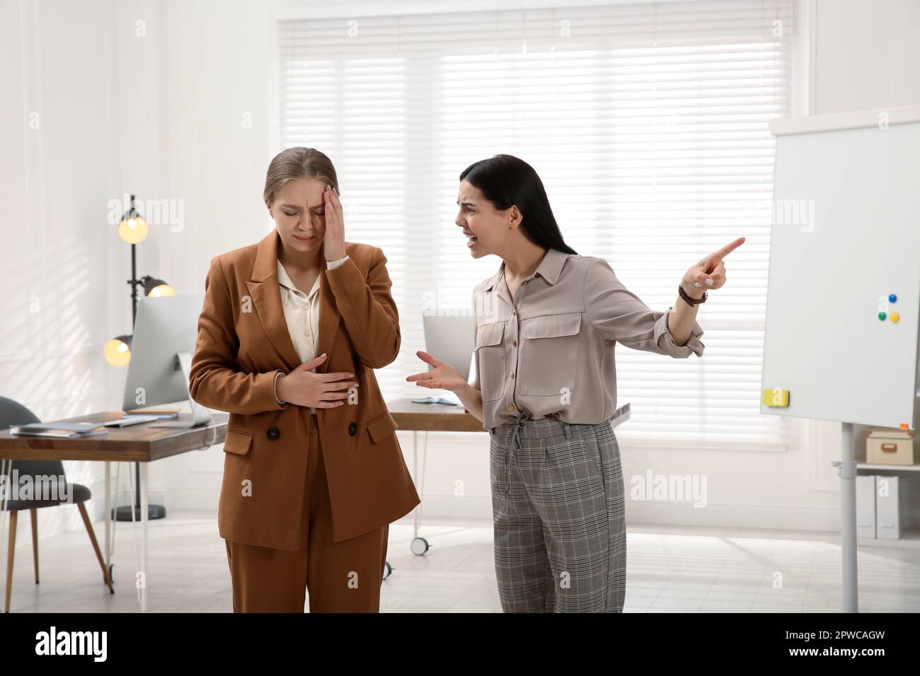 Boss screaming at employee in office. Toxic work environment Stock Photo