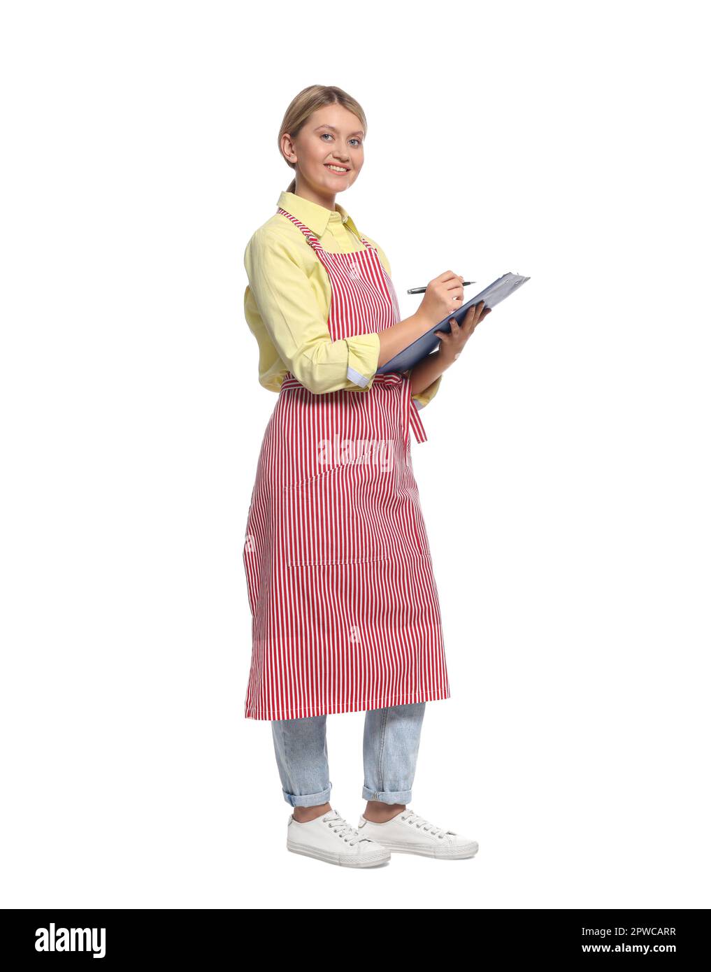 Beautiful young woman in clean striped apron with clipboard on white ...