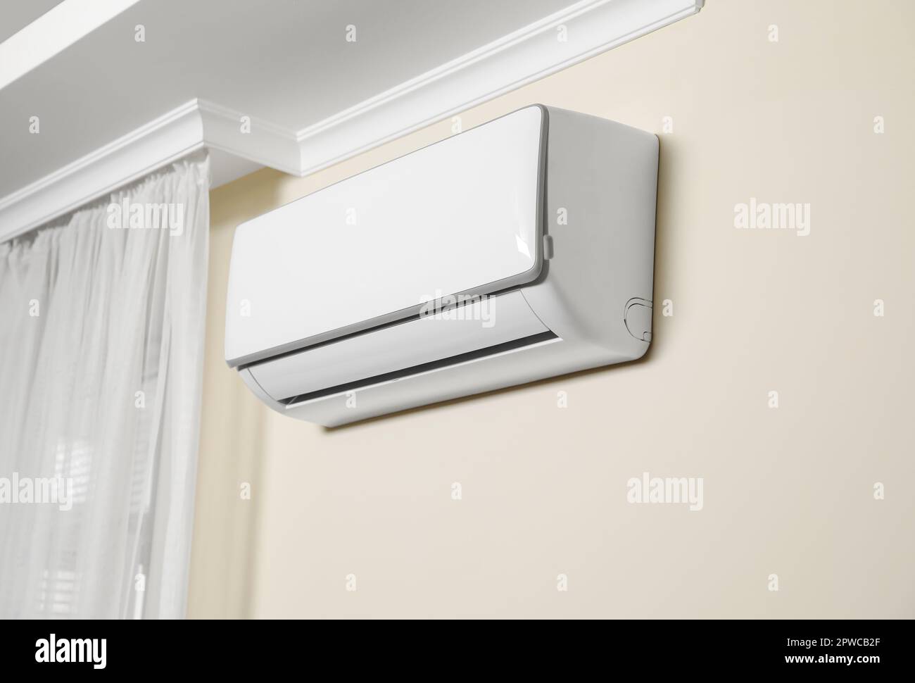 Modern air conditioner on white wall indoors Stock Photo - Alamy