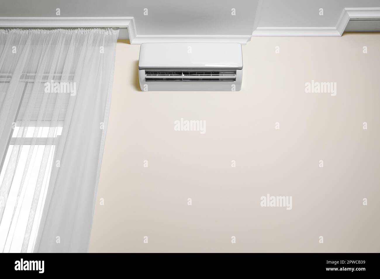 Modern air conditioner on white wall indoors Stock Photo - Alamy