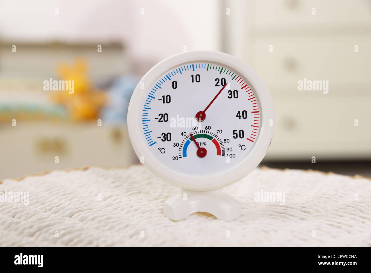 Round hygrometer with thermometer on mat in room Stock Photo Alamy