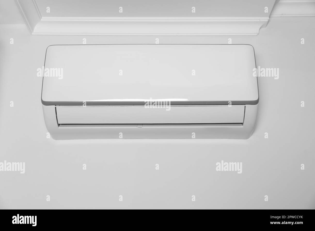 Modern air conditioner on white wall indoors Stock Photo - Alamy