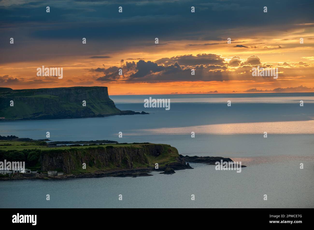 Sunset. looking over  White Park Bay, Portbradden to  Bengore Head, on the Causeway Coastal Route, Northern Ireland. Still ocean with a beautiful sky. Stock Photo