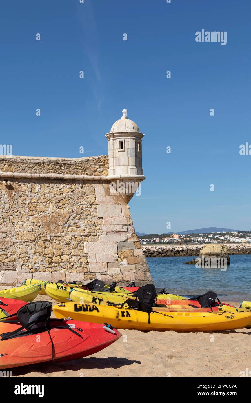 Kayaks on the sandy beach next to the Forte da Ponta da Bandeira, historic fortress in the port of Lagos, Faro district, Algarve, Portugal Stock Photo