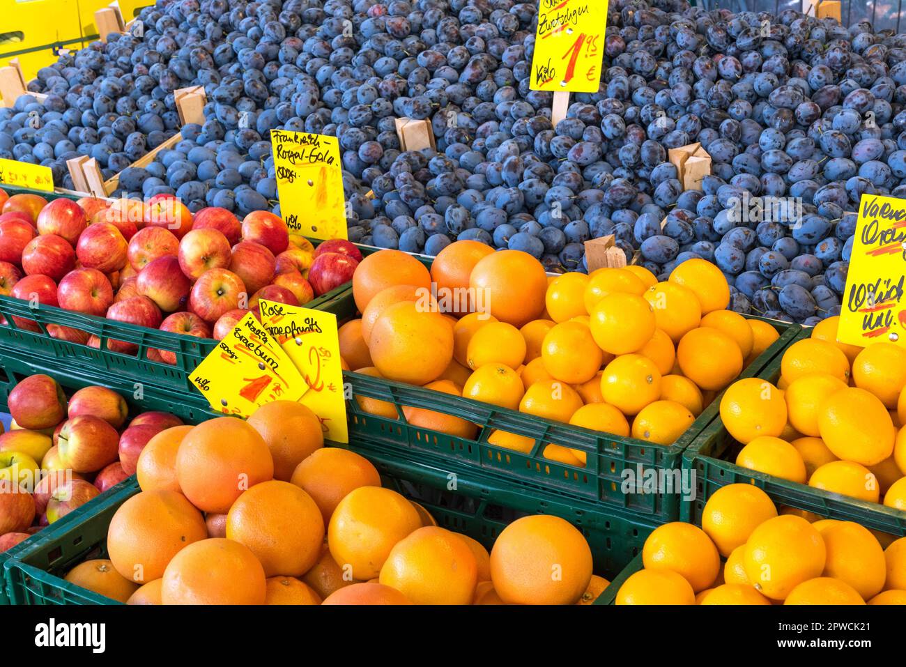 Plums, apples and oranges for sale at a market Stock Photo