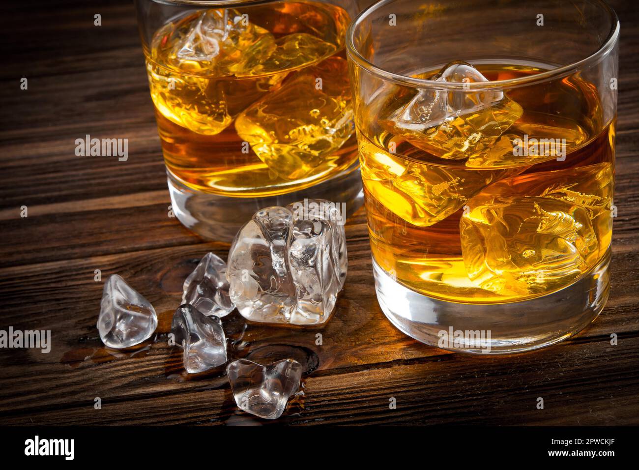 Bourbon whiskey in crystal glass garnished with ice, water droplets on side  of cup, with exquisite upscale bar background, blurred background focused  on glass on Craiyon