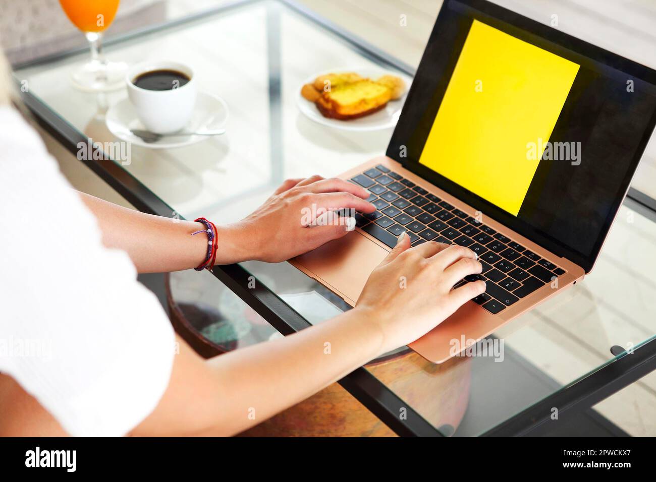 Woman drinking a coffee in the morning and using her laptop in the living room Stock Photo
