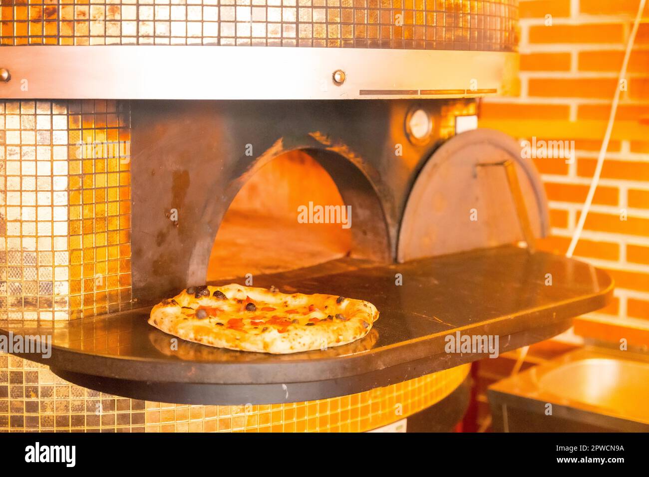 Artisan pizza oven. Pizza fresh out of the oven, pizza hot and ready for customers Stock Photo
