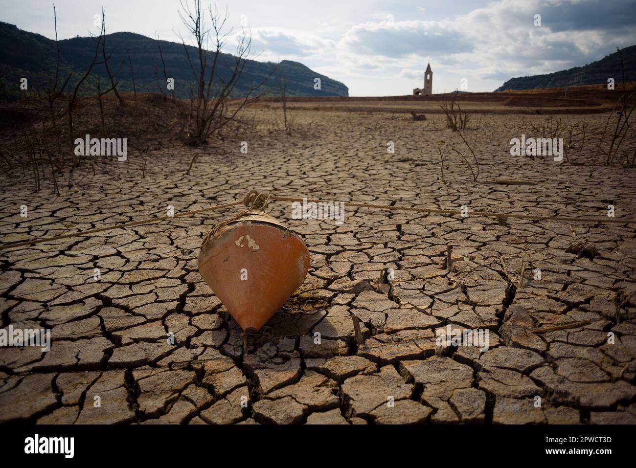 A buoy lays on dry soil clods at the Sau water reservoir. The water