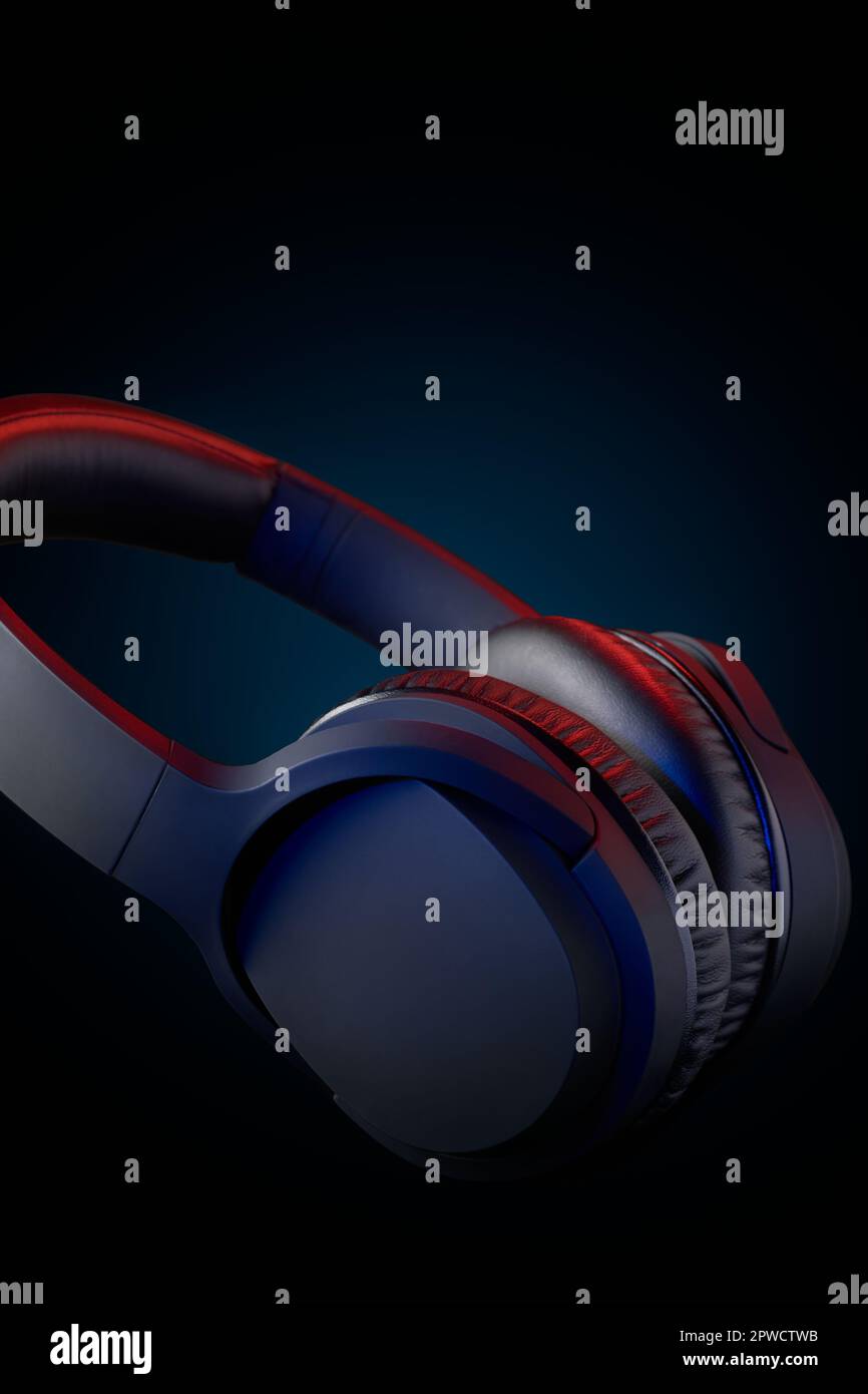 black headphone taken in soft focus, over-ear wireless audio equipment with noise canceling ear pads or ear cushions isolated dark background Stock Photo