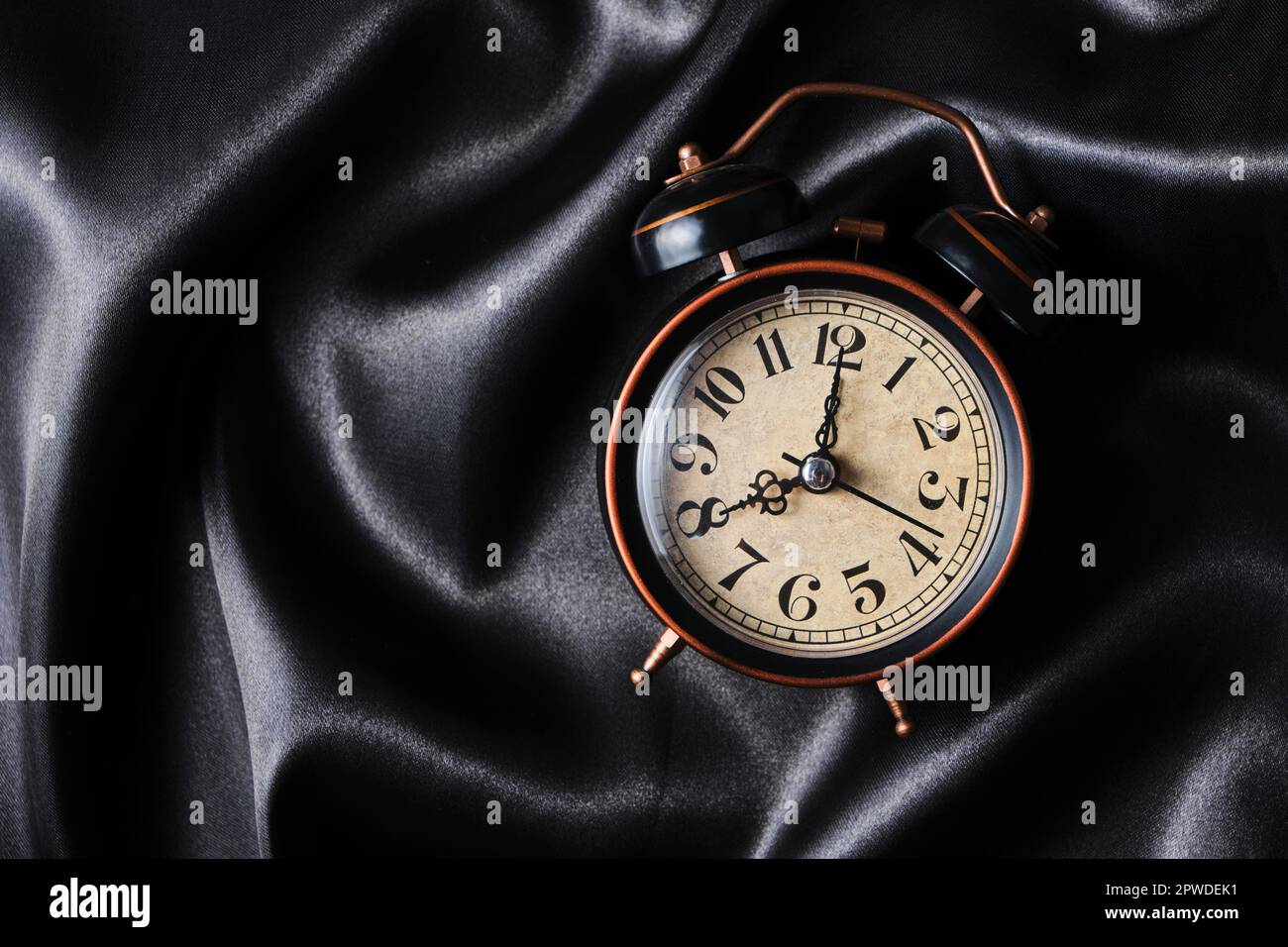 Eight morning alarm clock lying on silk bed linen Stock Photo Alamy