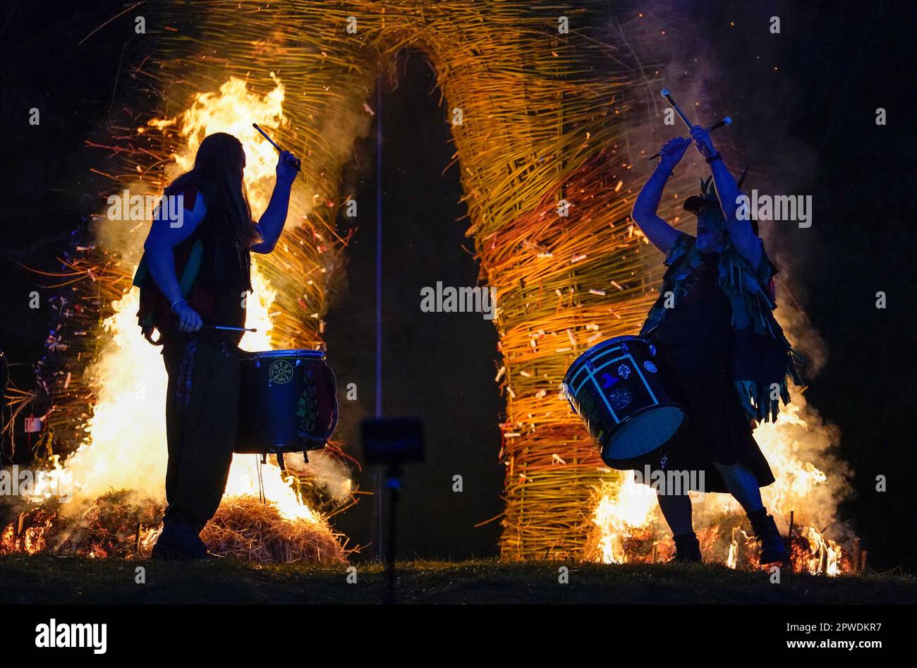 Members of the Pentacle Drummers perform in front of a burning wicker man during the Beltain Celtic Fire Festival at Butser Ancient Farm, in Waterlooville, Hampshire. Picture date: Saturday April 29, 2023. Stock Photo