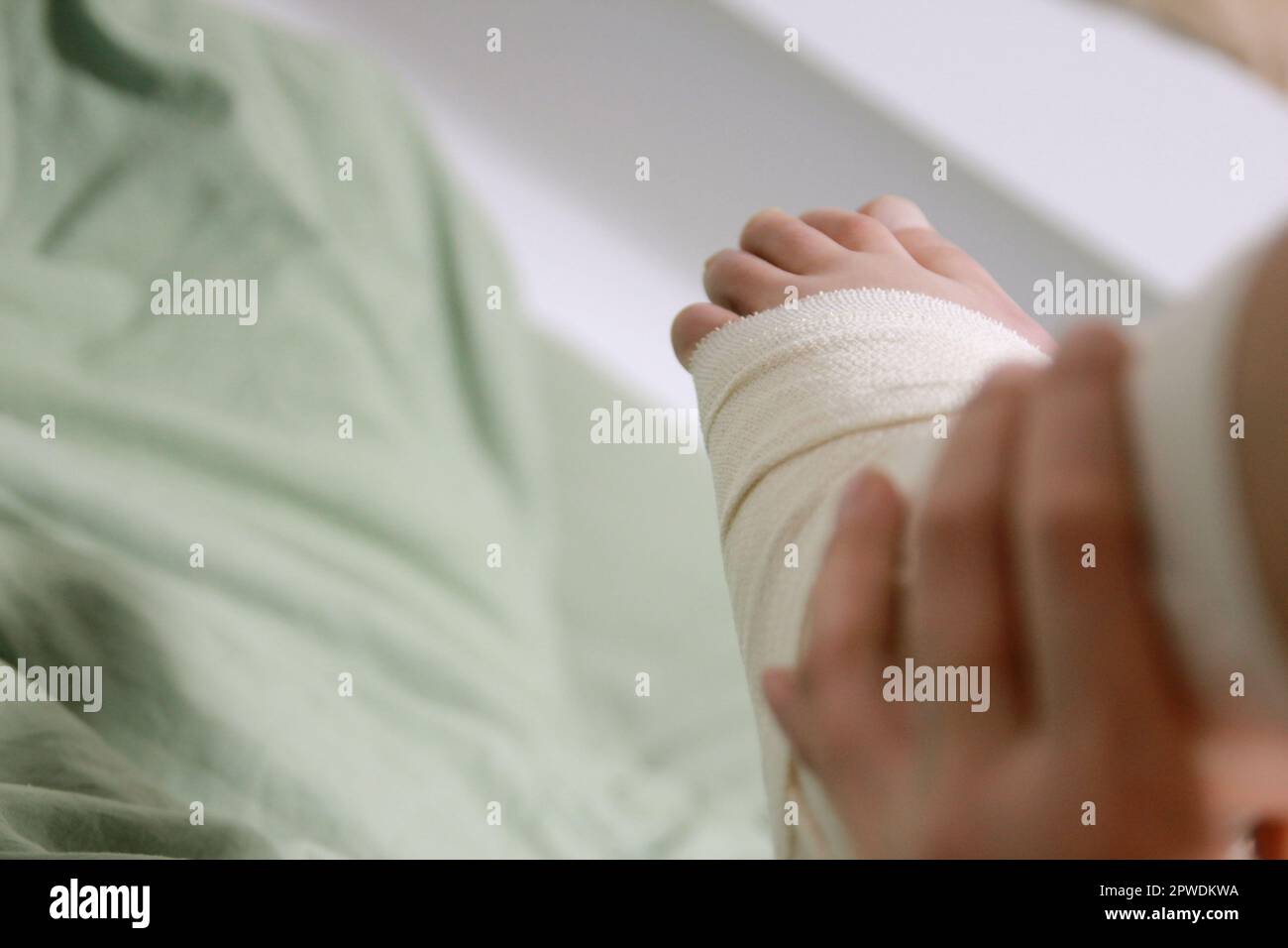 Concept of bandaging and treating an ankle injury at home Stock Photo