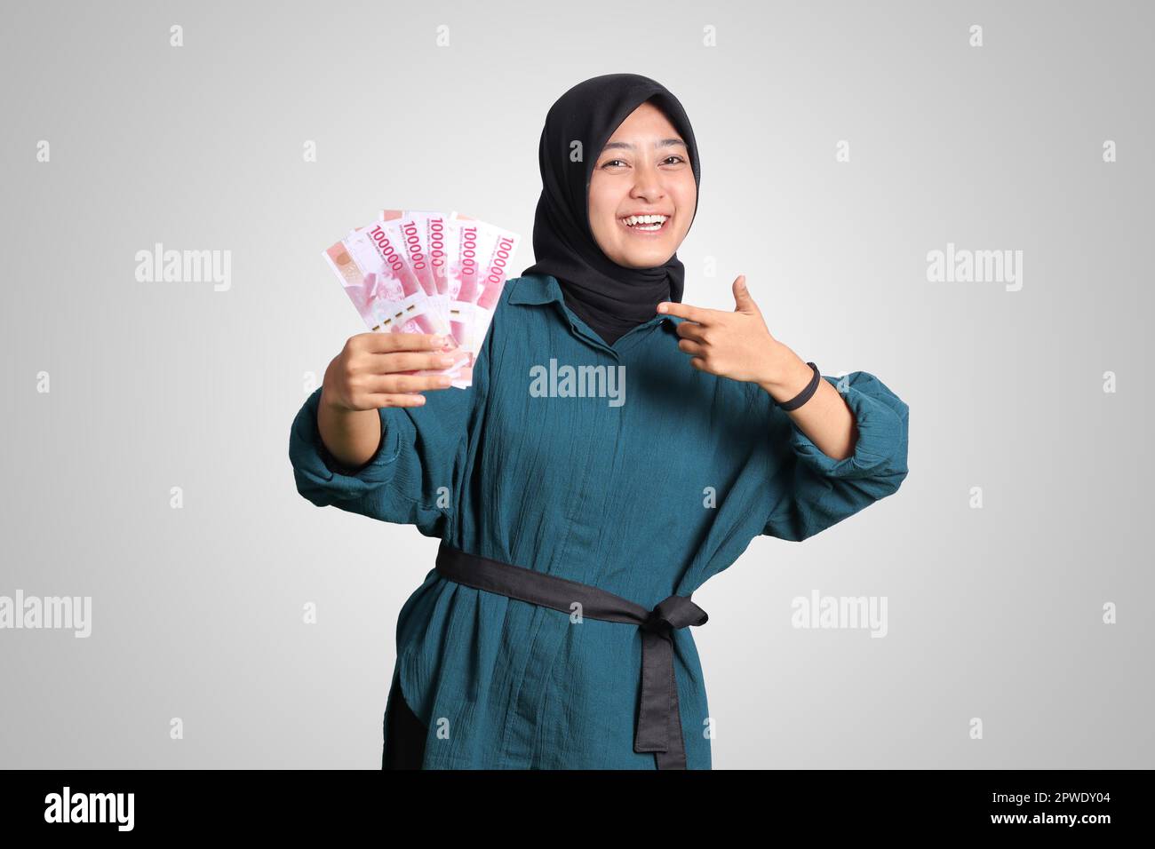 Portrait of excited Asian hijab woman in casual outfit showing and ...