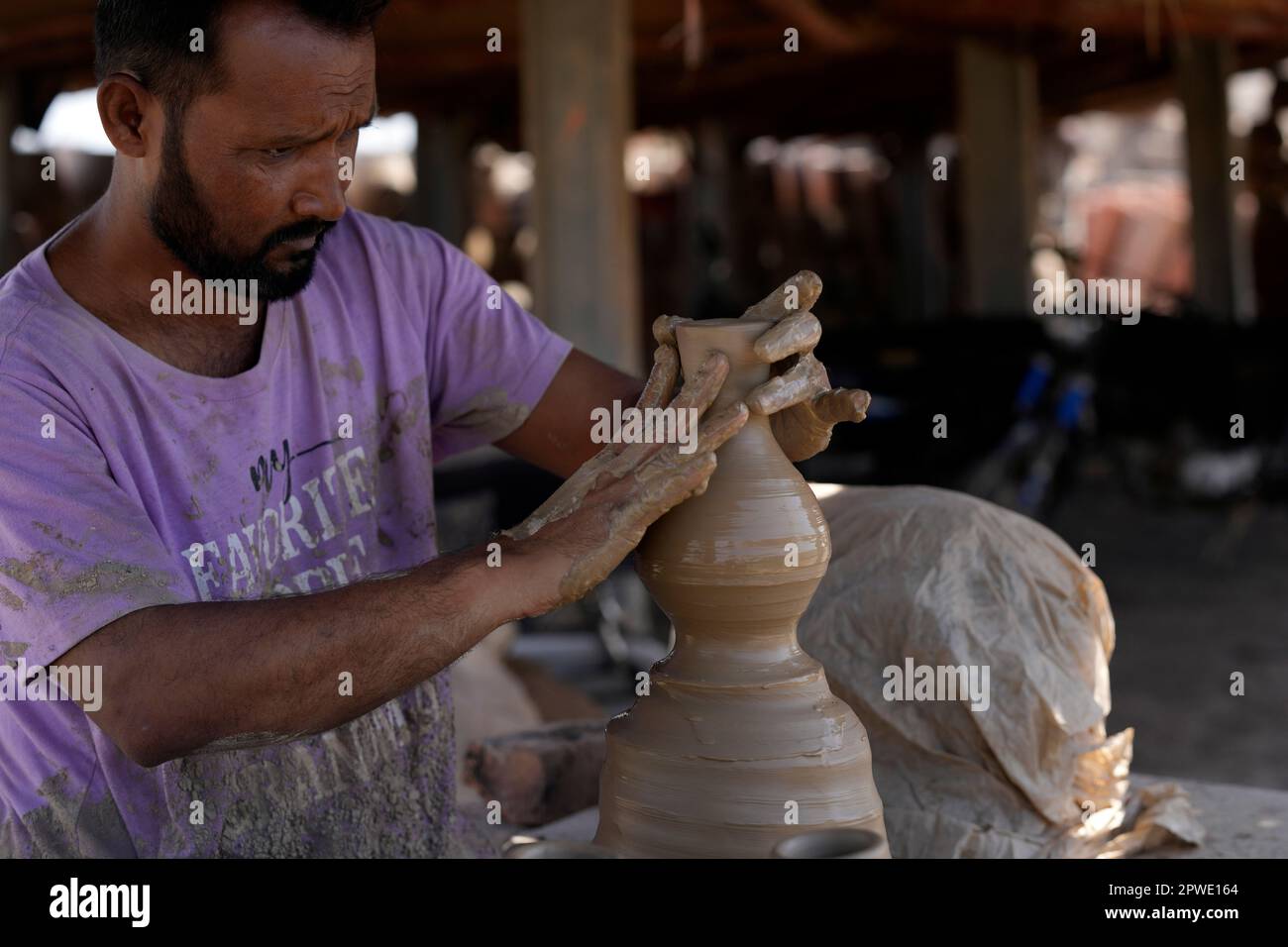 A potter makes a clay pot in Karachi, Pakistan, Sunday, April 30, 2023