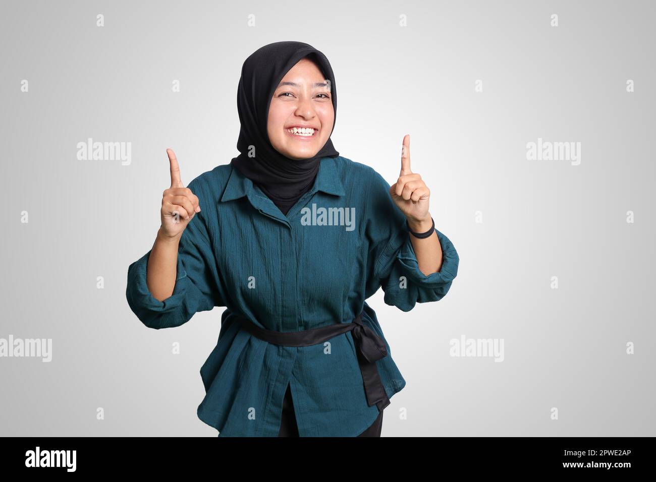 Portrait of excited Asian hijab woman in casual outfit standing against ...