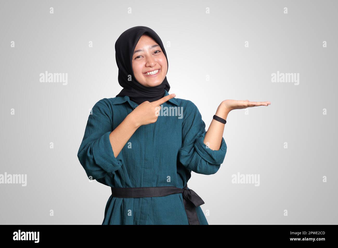 Portrait of excited Asian hijab woman in casual outfit standing against ...