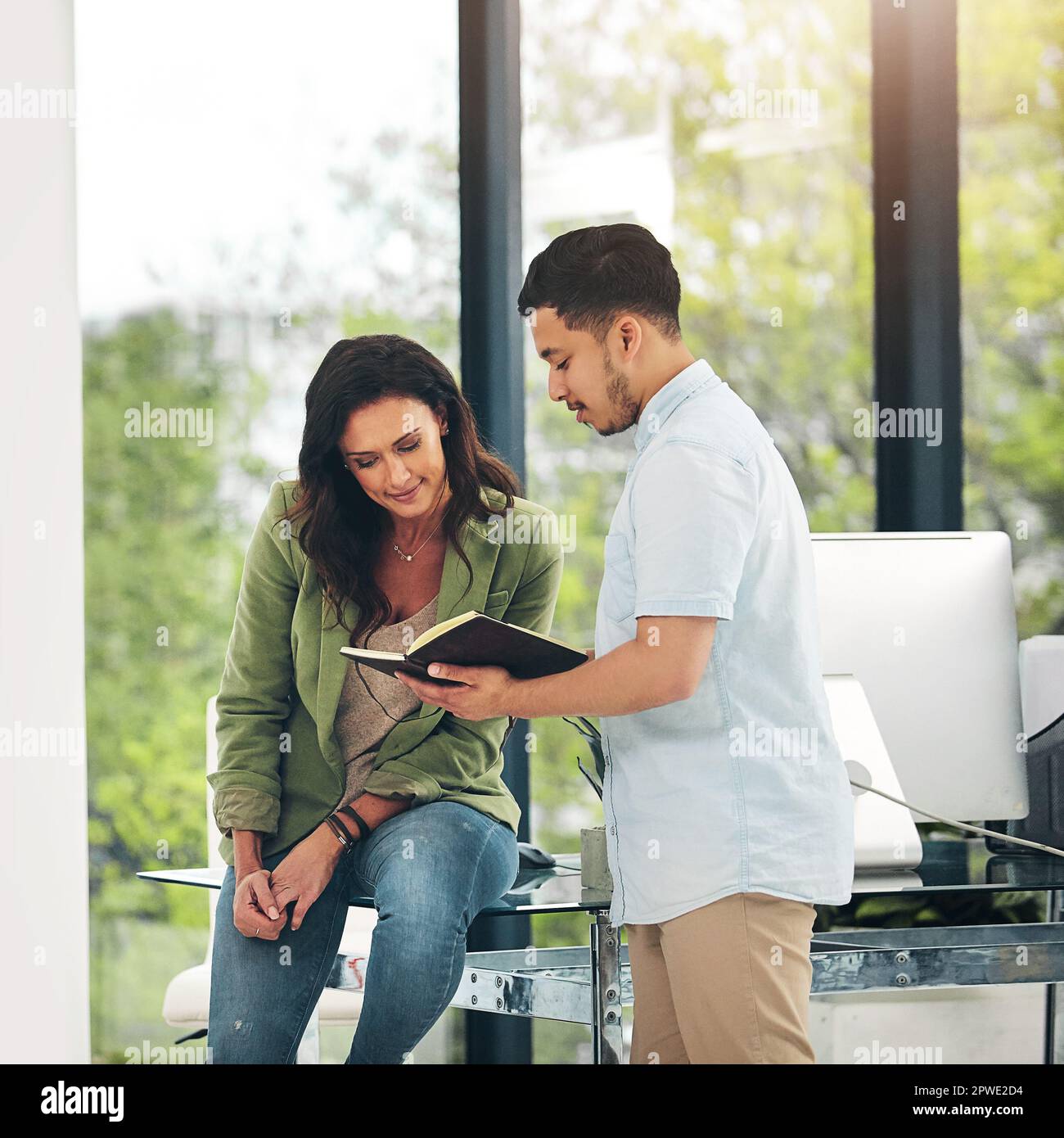 Heres what we discussed before. two creative colleagues sharing ideas in their office. Stock Photo
