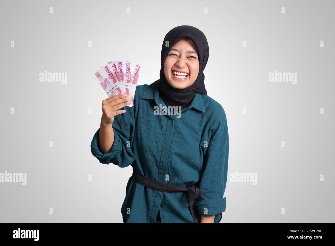 Portrait of excited Asian hijab woman in casual outfit showing one ...