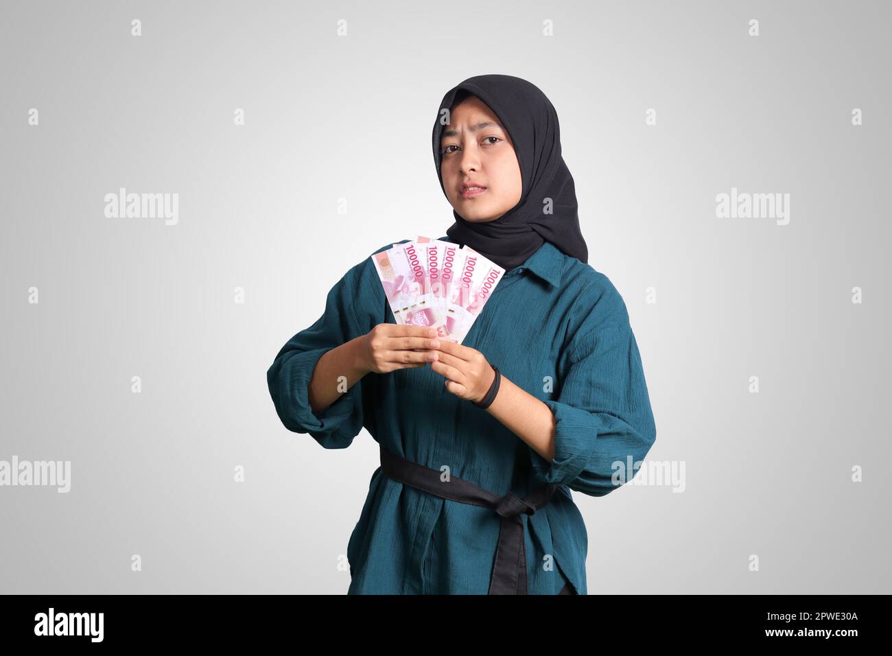 Portrait of excited Asian hijab woman in casual outfit showing one ...