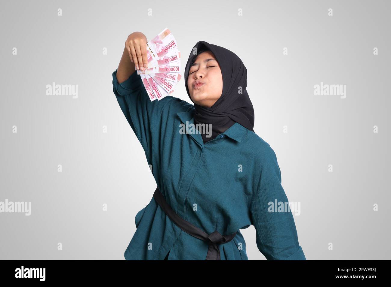 Portrait of excited Asian hijab woman in casual outfit showing one ...