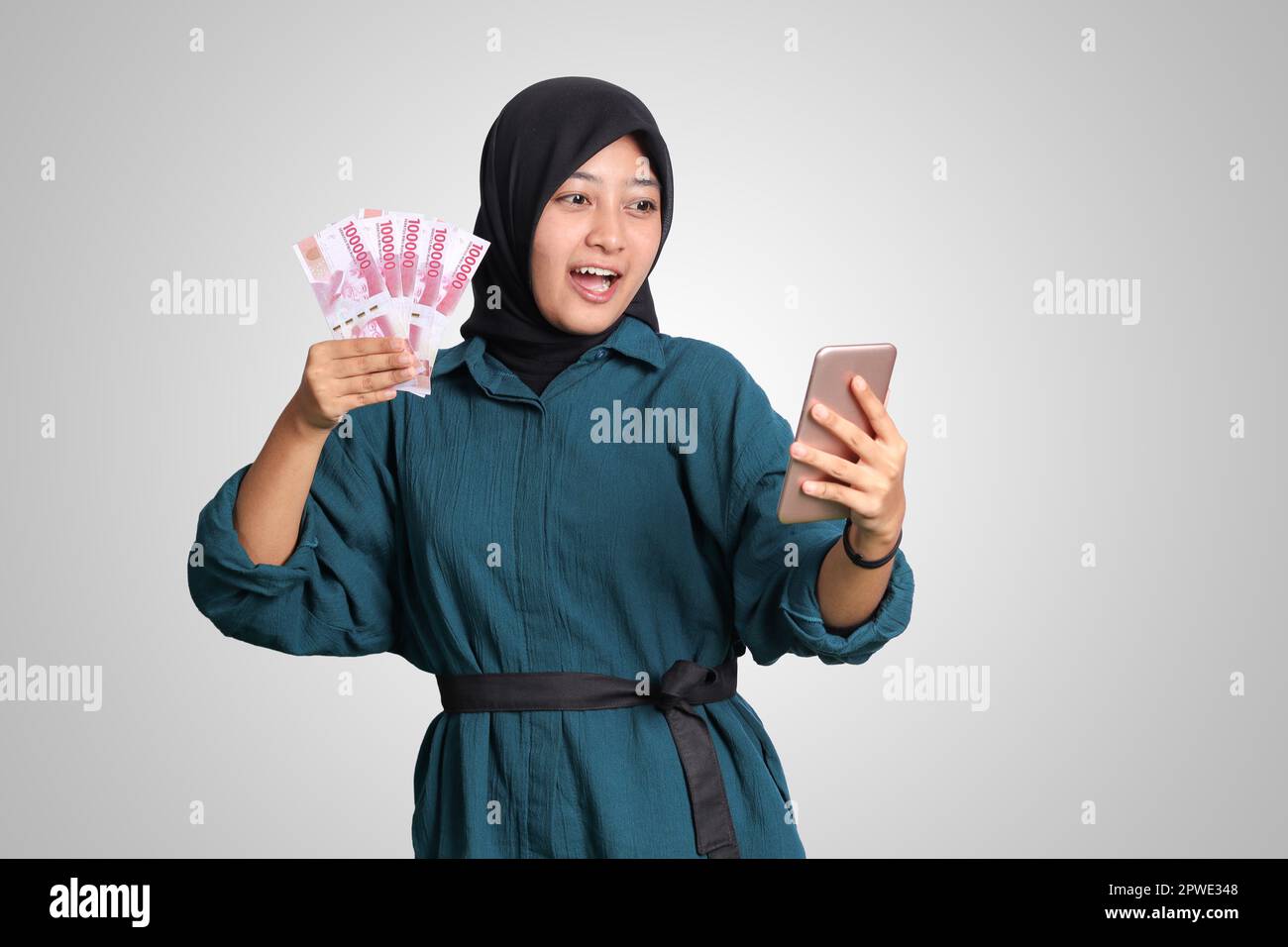 Portrait of excited Asian hijab woman in casual outfit showing one ...